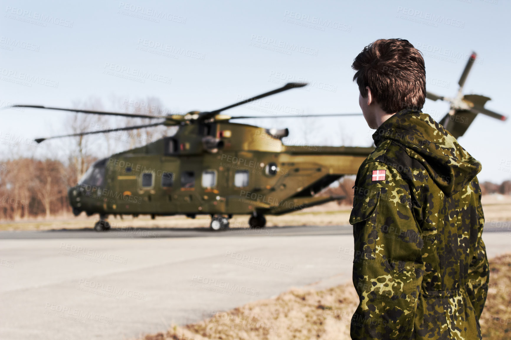 Buy stock photo Army, military or soldier man with a helicopter outdoor for transportation, Denmark war and pilot mission. Male person for combat, flight or air force service in camouflage uniform to watch or patrol