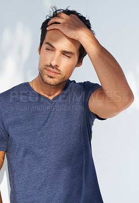 Buy stock photo A handsome young man with his hand in his hair