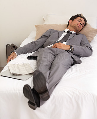 Buy stock photo A handsome young businessman asleep on the bed with his digital tablet