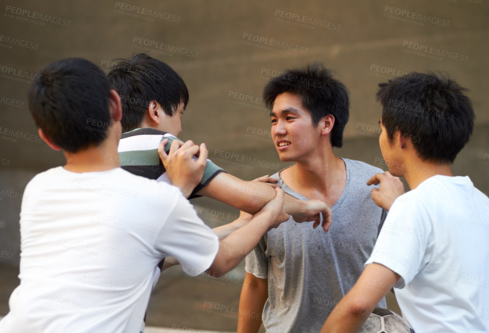 Buy stock photo Asian teen shoving his friend while another tries to break up the fight