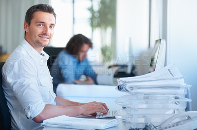 Buy stock photo Cropped shot of a businessman working in the office with his colleague in the background