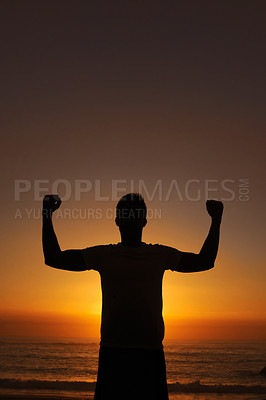 Buy stock photo Silhouette of a man standing with his arms victoriously raised against the sunset
