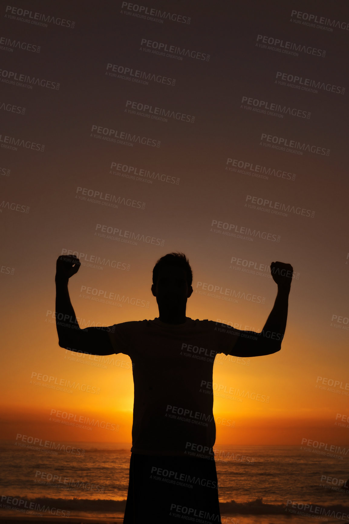 Buy stock photo Silhouette of a man standing with his arms victoriously raised against the sunset