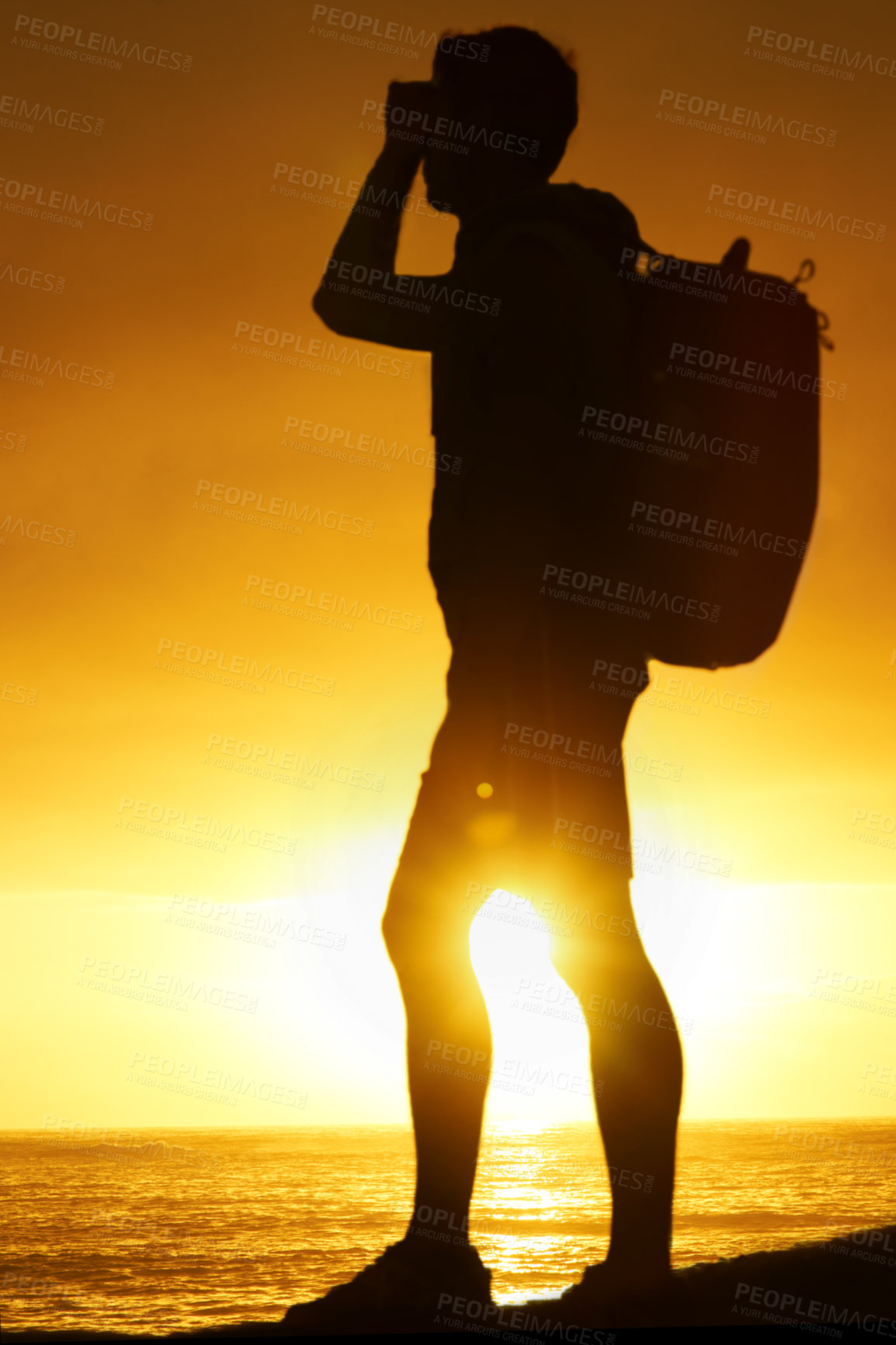Buy stock photo Silhouette, man and hiking at ocean with sunset, backpack and scenery for holiday or vacation is summer. Shadow, person and relaxing with view, adventure and hiker for recreation, travel or sun flare