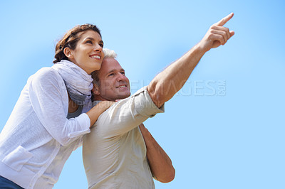 Buy stock photo Happy, couple and outdoor pointing to sky, together with love and happiness on adventure in summer. Vacation, travel and woman hug mature man sightseeing on holiday with mockup, space or background
