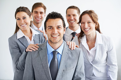 Buy stock photo A group of businesspeople standing proudly with their leader as he smiles at the camera