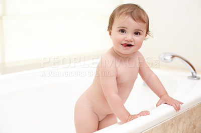 Buy stock photo Baby standing in bathtub with smile, water and clean fun in home for skincare, wellness or hygiene. Bubble bath, soap and happy child in bathroom with cute face, care and washing dirt, germs and foam