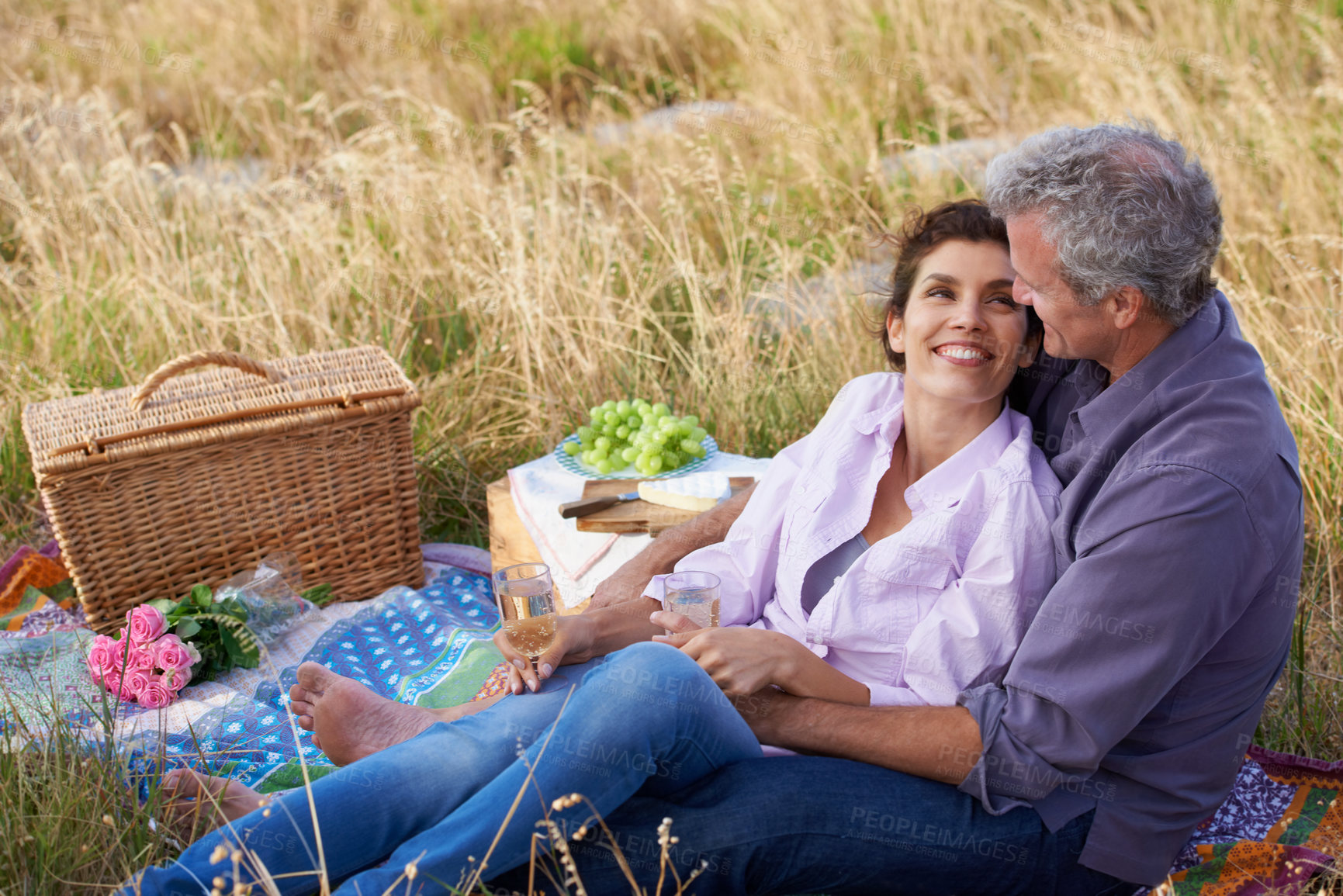 Buy stock photo Old couple, relax and picnic in park for a date with love, care or support in marriage. Outdoor, man and woman on grass in nature with food, flowers and celebration in retirement, holiday or vacation