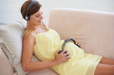 Buy stock photo Woman, music or headphones on pregnant stomach in home living room for sound, audio or listening development for baby. Relax, pregnancy or person with podcast for childcare wellness or growth support