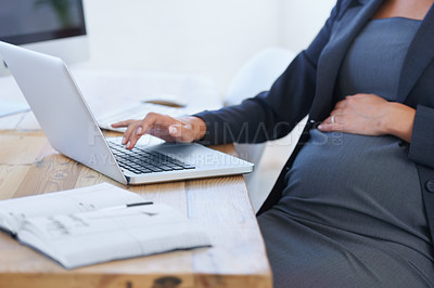 Buy stock photo Cropped image of a pregnant businesswoman working on her laptop in the office