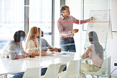 Buy stock photo Planning, mature mentor with colleagues and chart in a boardroom of their modern workplace. Teamwork or collaboration, data review or brainstorming and coworkers working together in business meeting