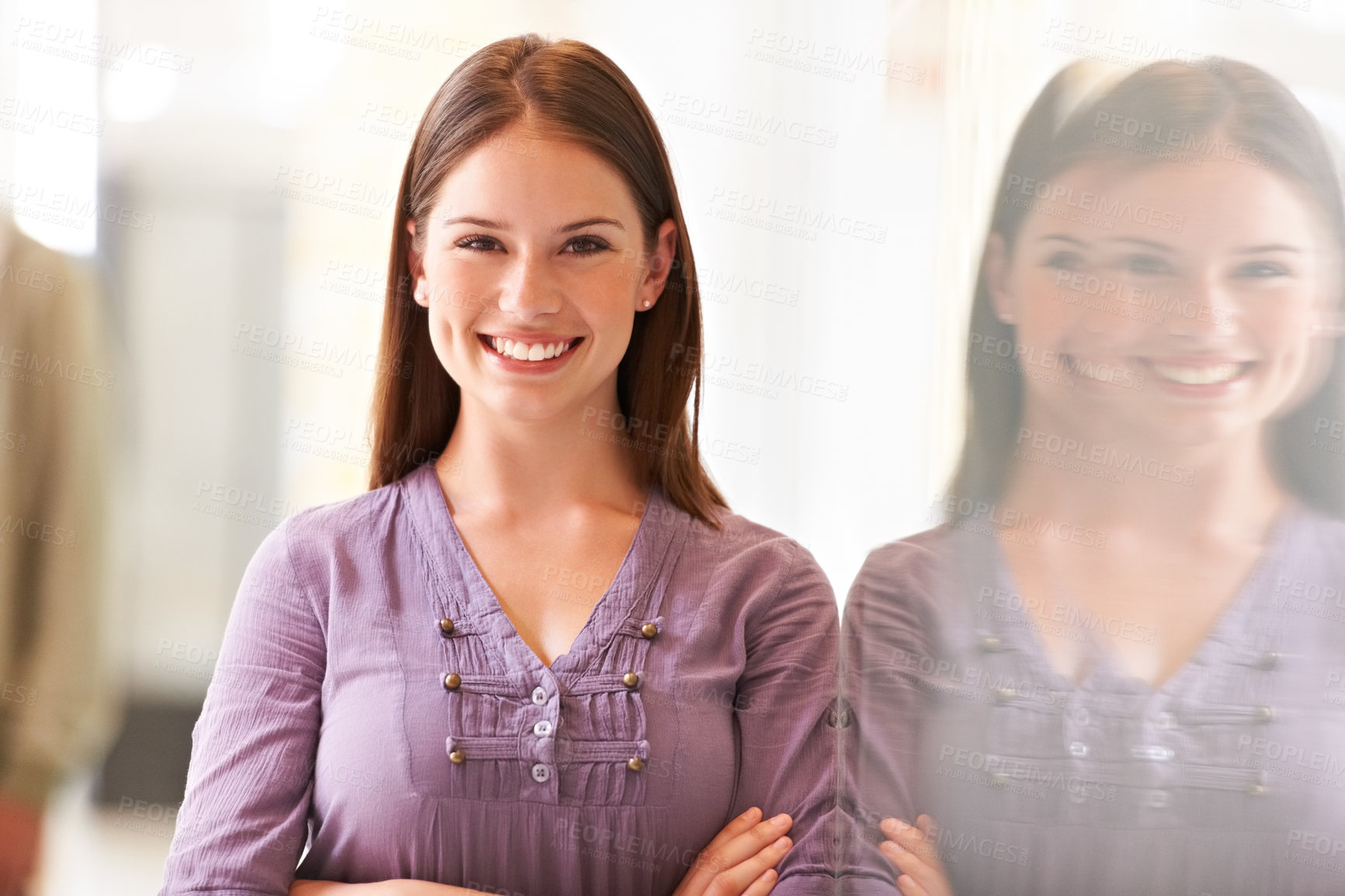 Buy stock photo Smiling young businesswoman dressed casually for work and standing with her arms folded