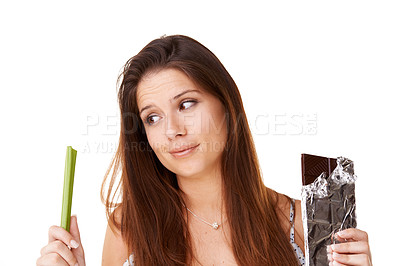Buy stock photo Decision, celery and chocolate with woman, choice and girl isolated on a white studio background. Nutrition, person and model with candy, vegan or diet plan with health, wellness and sweet with doubt