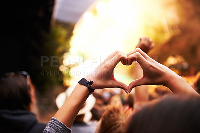 Buy stock photo A young woman gesturing a heart towards the stage at a music festival