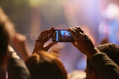 Buy stock photo Music, concert and phone camera in the audience to record a performance on stage at a festival or event. Party, video or photograph with a person in the crowd of a stadium at night holding a mobile