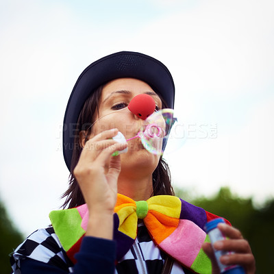 Buy stock photo Clown blowing bubbles at outdoor festival for fun, fantasy and summer adventure in nature. Face of person, street performer or circus character in park with creative color at happy carnival event.