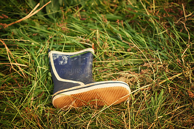 Buy stock photo Boot, grass and outdoor with nature, day and lost with environment, sunshine and countryside. Outside, empty and single shoe with footwear, ground and missing with field and abandon with summer