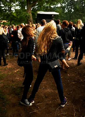 Buy stock photo Friends, dancing and fun at outdoor music festival, party and freedom or energy at concert. Women, back and crazy at event, entertainment and bonding outside for friendship, crowd and rave or fashion