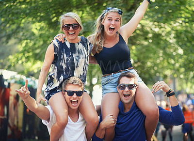 Buy stock photo Two guys carrying their girlfriends on their shoulders at a music festival