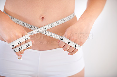 Buy stock photo Hands, body and woman with tape measure on abdomen in underwear for weight loss, health and wellness isolated on a white studio background. Closeup, stomach and girl measuring waist for diet or care