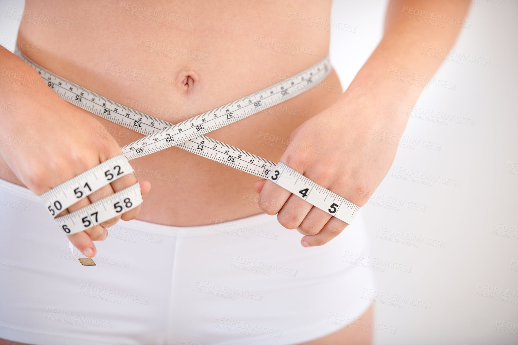 Buy stock photo Hands, body and woman with tape measure on abdomen in underwear for weight loss, health and wellness isolated on a white studio background. Closeup, stomach and girl measuring waist for diet or care