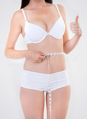 Buy stock photo Stomach, thumbs up and woman with tape measure in underwear for weight loss, body health and wellness isolated on a white studio background. Success, hand sign and slim waist, abdomen of girl or diet