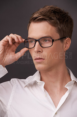 Buy stock photo Man, thinking and serious nerd with glasses, fashion or choice in eyewear on dark background of studio. Optometry, check and geek with spectacles, style and person with prescription lenses in frame 