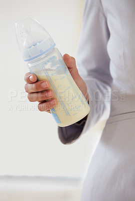 Buy stock photo Business, woman and baby bottle with mom in suit, working and balance a career with motherhood. Hand, closeup and mother with milk in container for child, care and management of family with a job