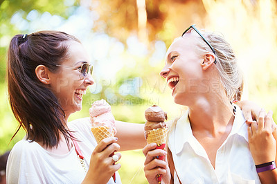 Buy stock photo Two young teens eating ice cream together in the sunshine while laughing with joy