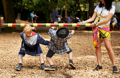 Buy stock photo Shot of two kids doing the limbo at an outdoor festival