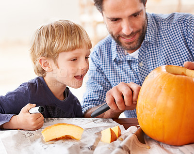 Buy stock photo A father and son carving a pumpkin in the kitchen for halloween
