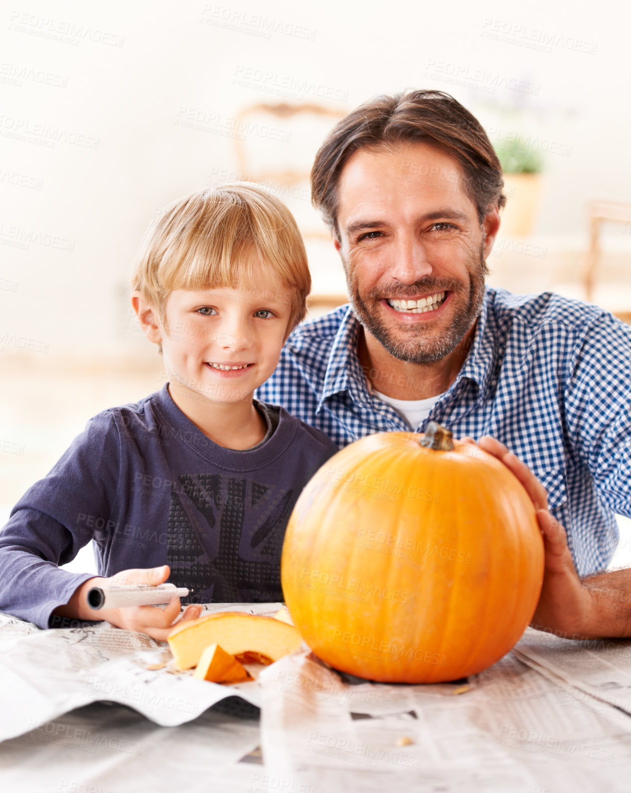 Buy stock photo Portrait of a father and son carving a pumpkin in the kitchen for halloween