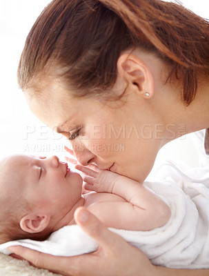 Buy stock photo Mother, kiss and newborn baby in closeup with love, happiness and care in bedroom at family home. Young mom, infant child and hug with happy bonding, pride and together on bed in morning at house