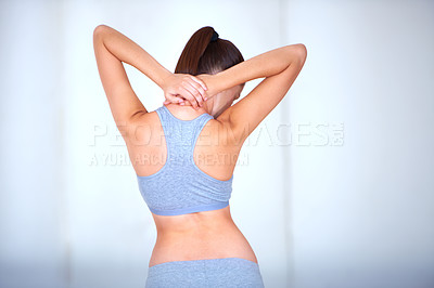 Buy stock photo Rearview of a young woman holding her neck and stretching