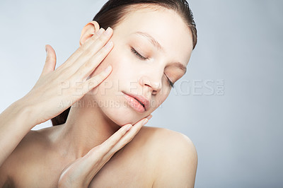 Buy stock photo Head and shoulder shot of a beautiful young woman in the nude with eyes closed and hand on her face