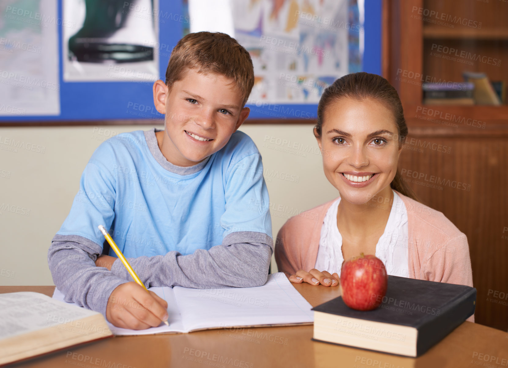 Buy stock photo Happy teacher, student and portrait in support for education, learning or tutor in classroom at school. Woman, mentor or teaching boy with smile in writing exam, literature or test for help in class