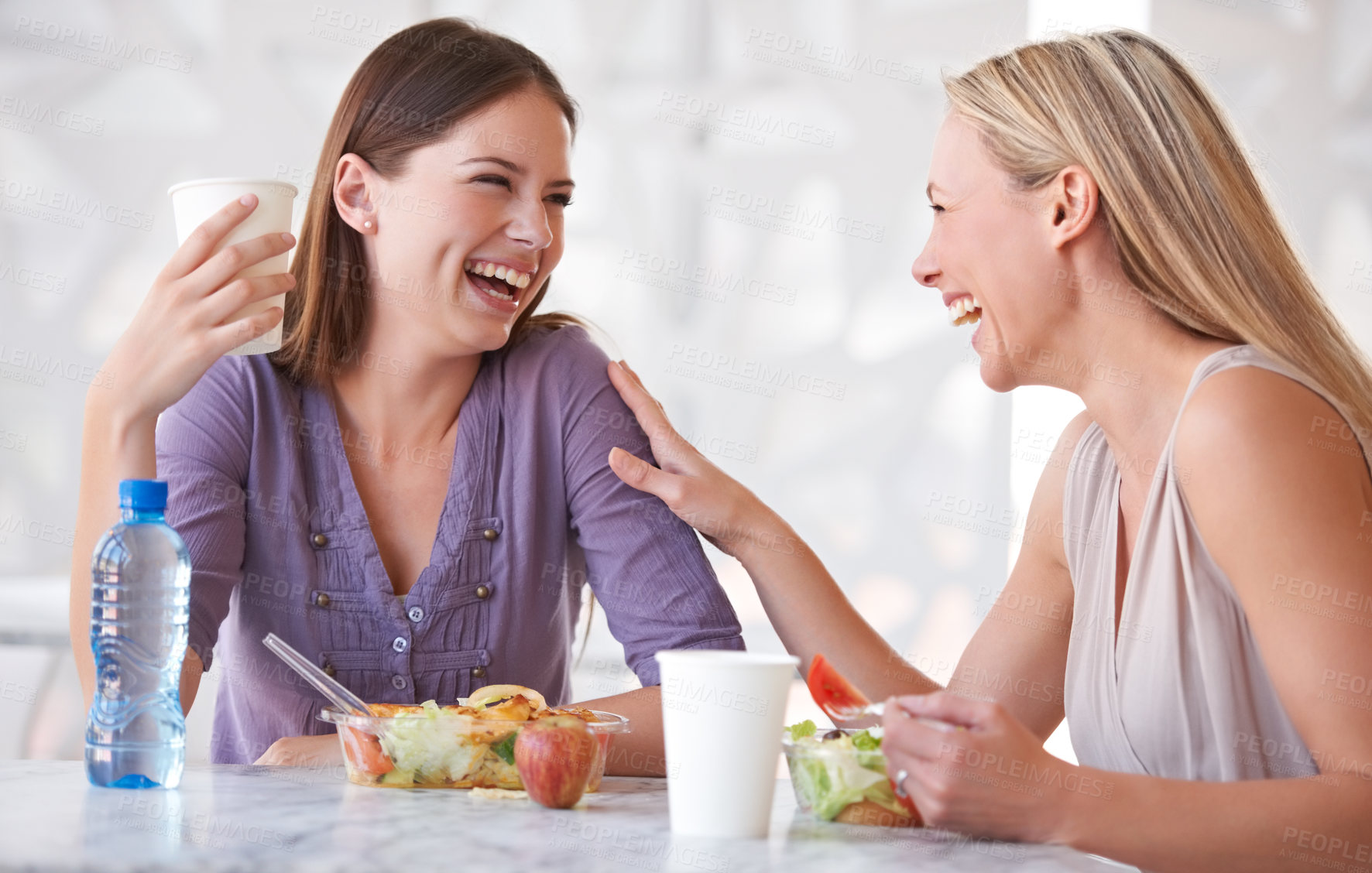 Buy stock photo Laughing, colleagues or friends at lunch in cafeteria with funny conversation, smile and eating. Healthy food, drinks and happy women in cafe for gossip, bonding and employees in break room together.
