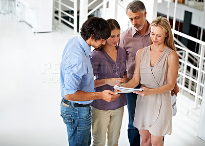 Buy stock photo Business people, paperwork and discussing together in lobby, planning and brainstorming in office. Team, support and collaboration or group of employees in communication, ideas and problem solving
