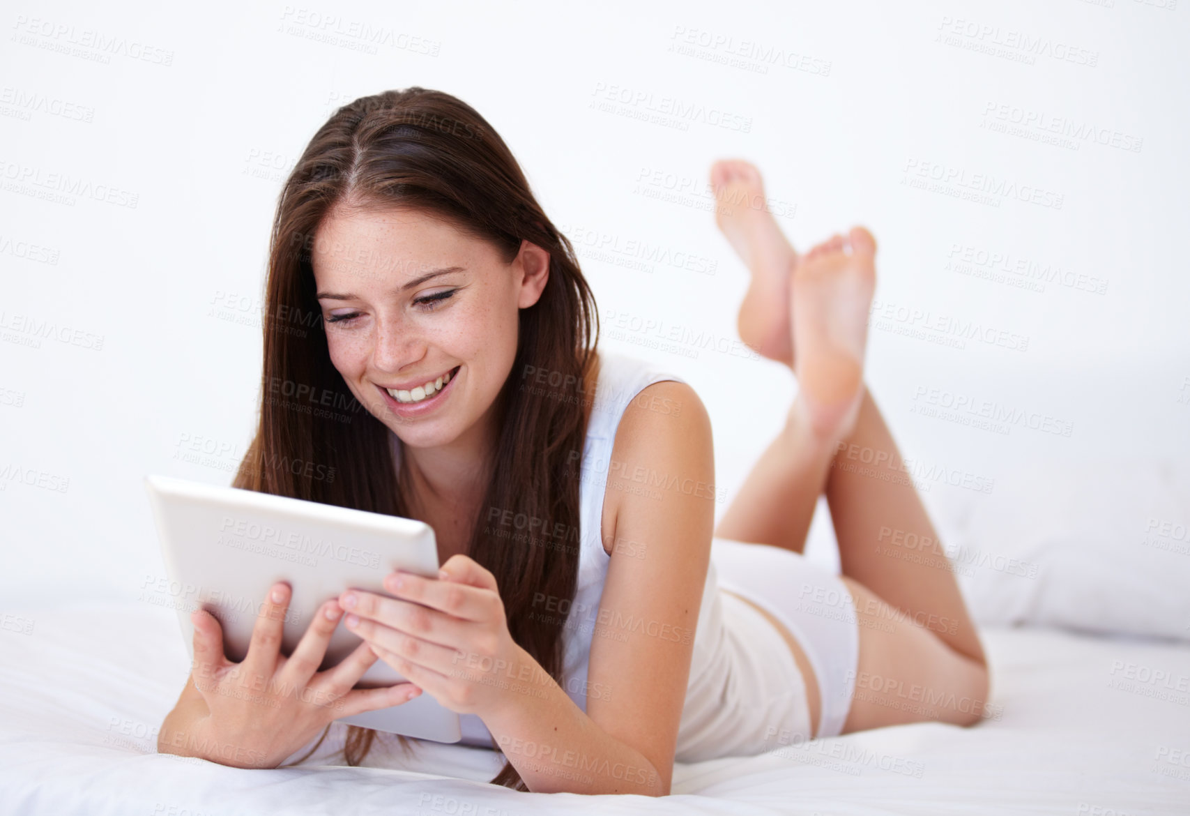 Buy stock photo Woman in underwear, tablet and relax on bed with internet, social media or online streaming service for film choice or movies. Happy young person reading on digital technology in bedroom or at home