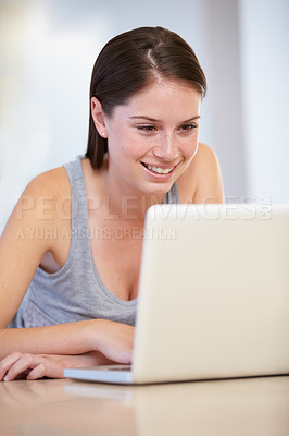 Buy stock photo Home, laptop and woman or student in e learning, online education and typing for university or college research. Young person at a table or desk and reading on computer for website results or news