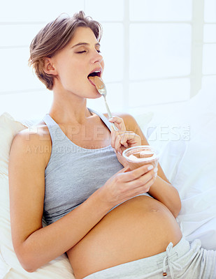 Buy stock photo Relax, pregnant and a woman eating pudding on a sofa in the living room of her home for hunger craving. Happy, food or chocolate dessert with a young mother in her apartment for pregnancy growth
