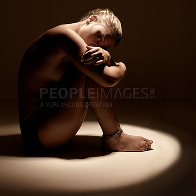 Buy stock photo Shot of a young woman embracing herself in the studio