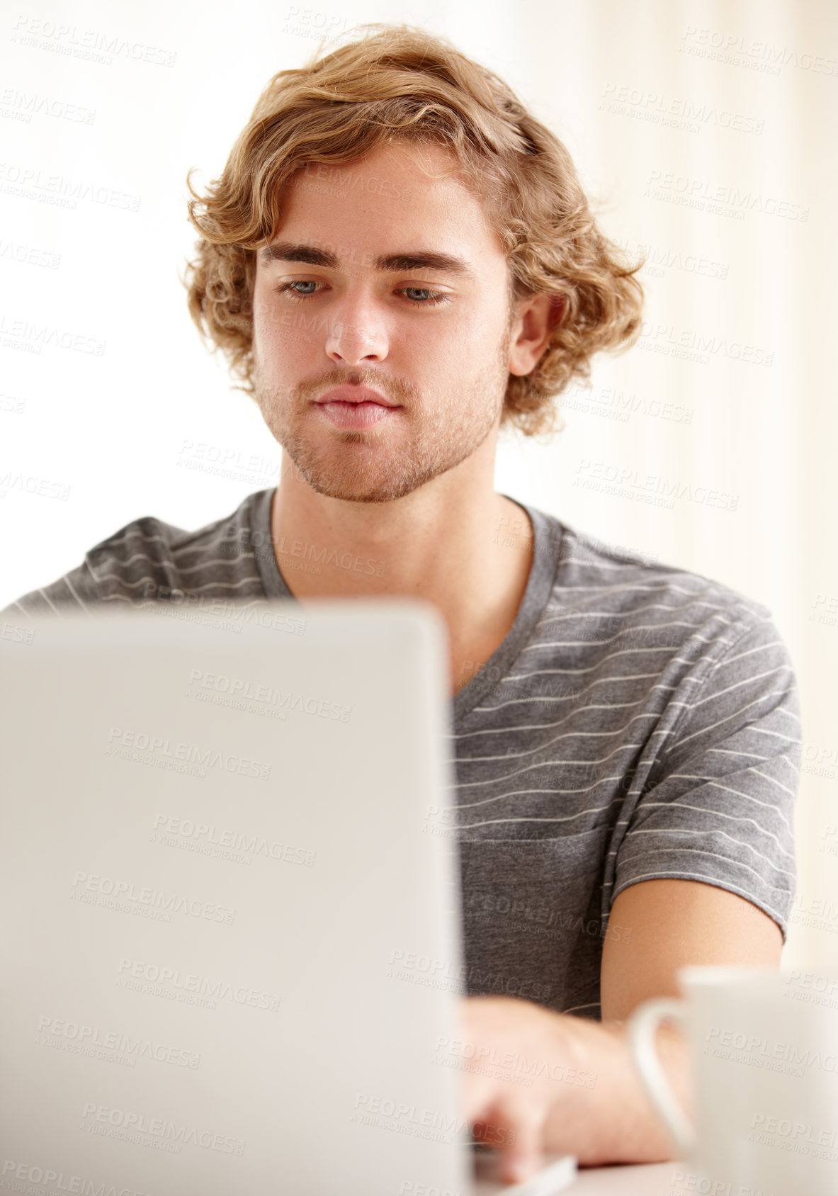 Buy stock photo A young man woking on his laptop at home