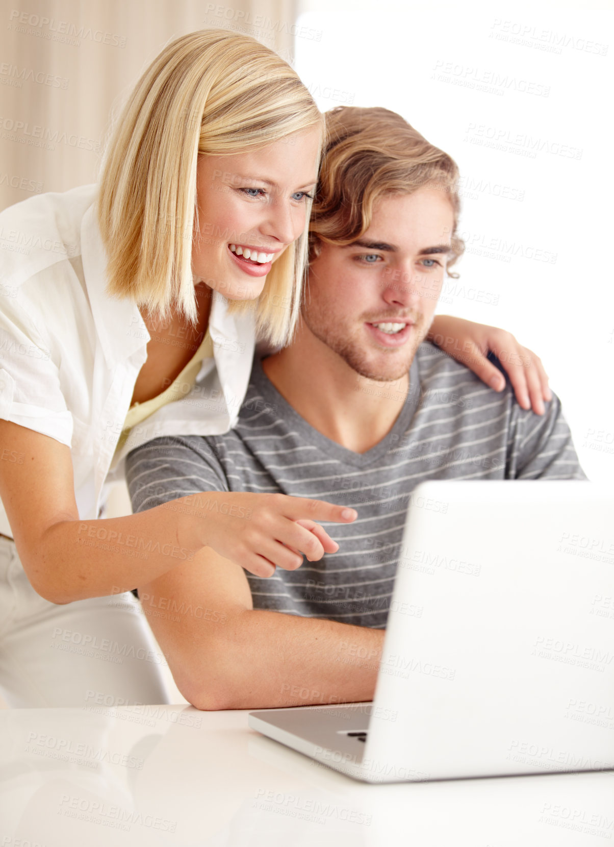 Buy stock photo A happy young couple using a laptop to surf the internet