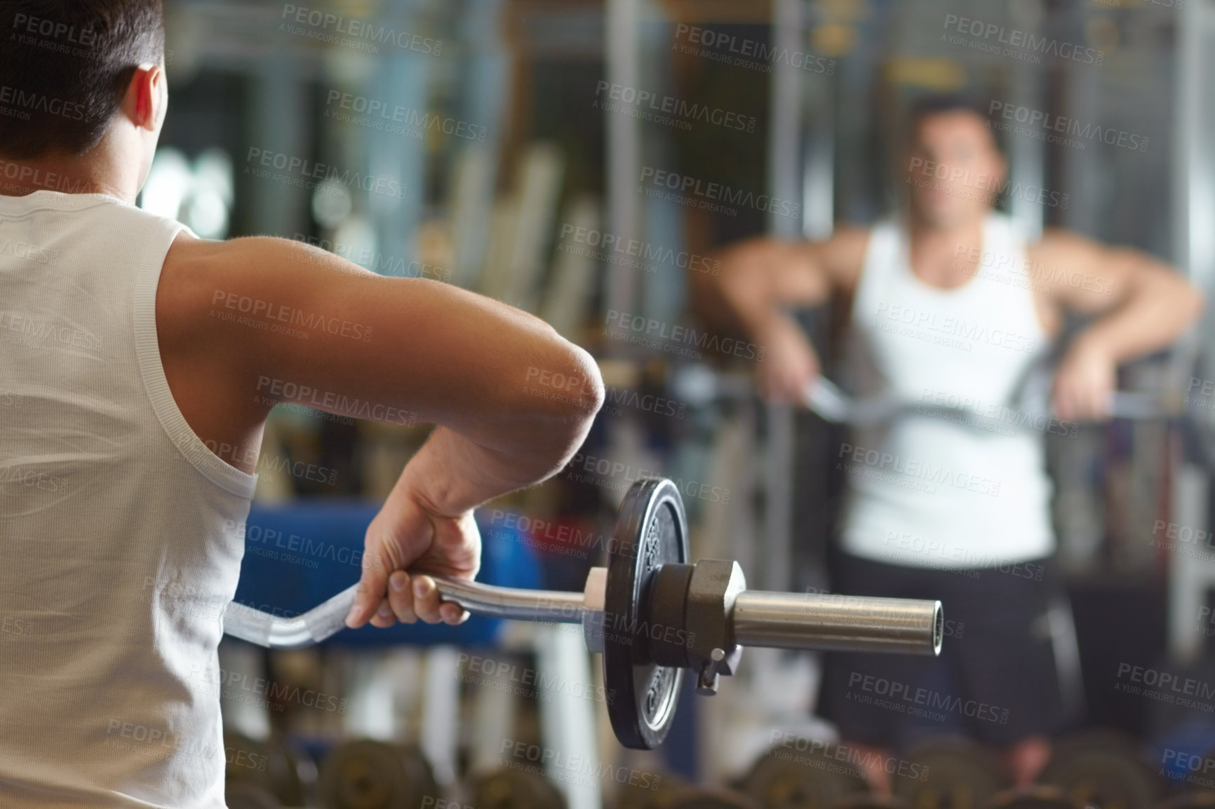 Buy stock photo Rearview shot of a muscular young man working out in the gym