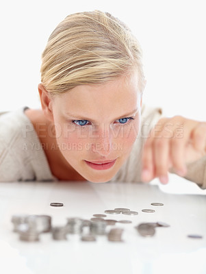 Buy stock photo Shot of a beautiful woman looking at coins on the table in front of her