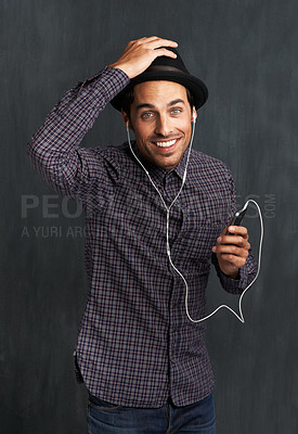 Buy stock photo Man, portrait and cellphone or earphones for music listening in studio entertainment, streaming or black background. Male person, face and hipster fashion or online indie playlist, radio or mockup