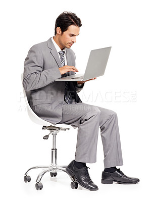 Buy stock photo A focused young executive working on his laptop while isolated on white