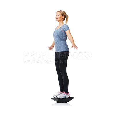 Buy stock photo A pretty young blond standing on a balance board while isolated on white