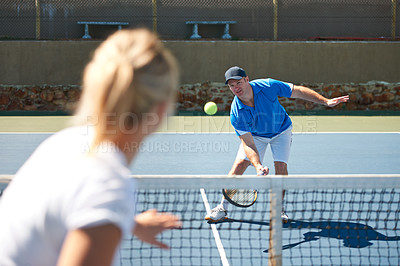 Buy stock photo A male tennis player lobbing the ball over the net